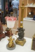 Two bronze or ormolu cherubic table lamps, one with shade. Tallest 58cm total