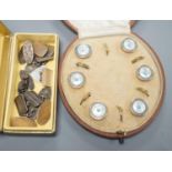 A cased early 20th century six piece gilt metal, mother of pearl and enamel dress stud set and