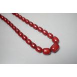 A single strand graduated oval simulated cherry amber bead necklace, 78cm, gross weight 121 grams.