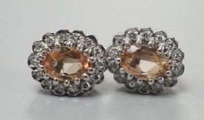 A pair of modern 9ct gold, topaz and diamond set oval cluster earrings, 11mm, gross weight 2.8