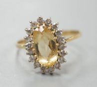 A modern yellow metal, yellow topaz and diamond set oval cluster ring, size T, gross weight 3.7