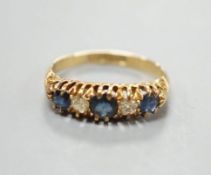 A George V 18ct gold, three stone sapphire and two diamond set half hoop ring, size M, gross 3.1
