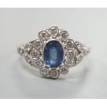 A yellow metal, sapphire and diamond set oval cluster ring, size T, gross weight 3.8 grams.