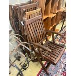 A set of four stained teak folding garden elbow chairs