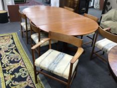 A 1950s teak Danish extending dining table and six chairs, two with arms, table extended 229cm,