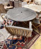 A circular weathered teak folding wooden garden table, diameter 110cm height 72cm, together with