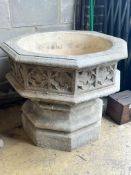 A reconstituted stone garden planter modelled as a Gothic font, width 80cm height 69cm