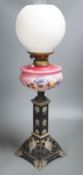 A Victorian cast iron and enamelled glass oil lamp