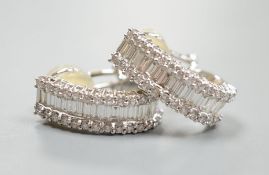 A modern pair of 18k white metal and three row baguette and diamond chip set shaped half hoop