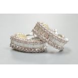 A modern pair of 18k white metal and three row baguette and diamond chip set shaped half hoop