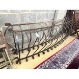 A pair of wrought iron bowed balcony rails, larger width 234cm height 73cm