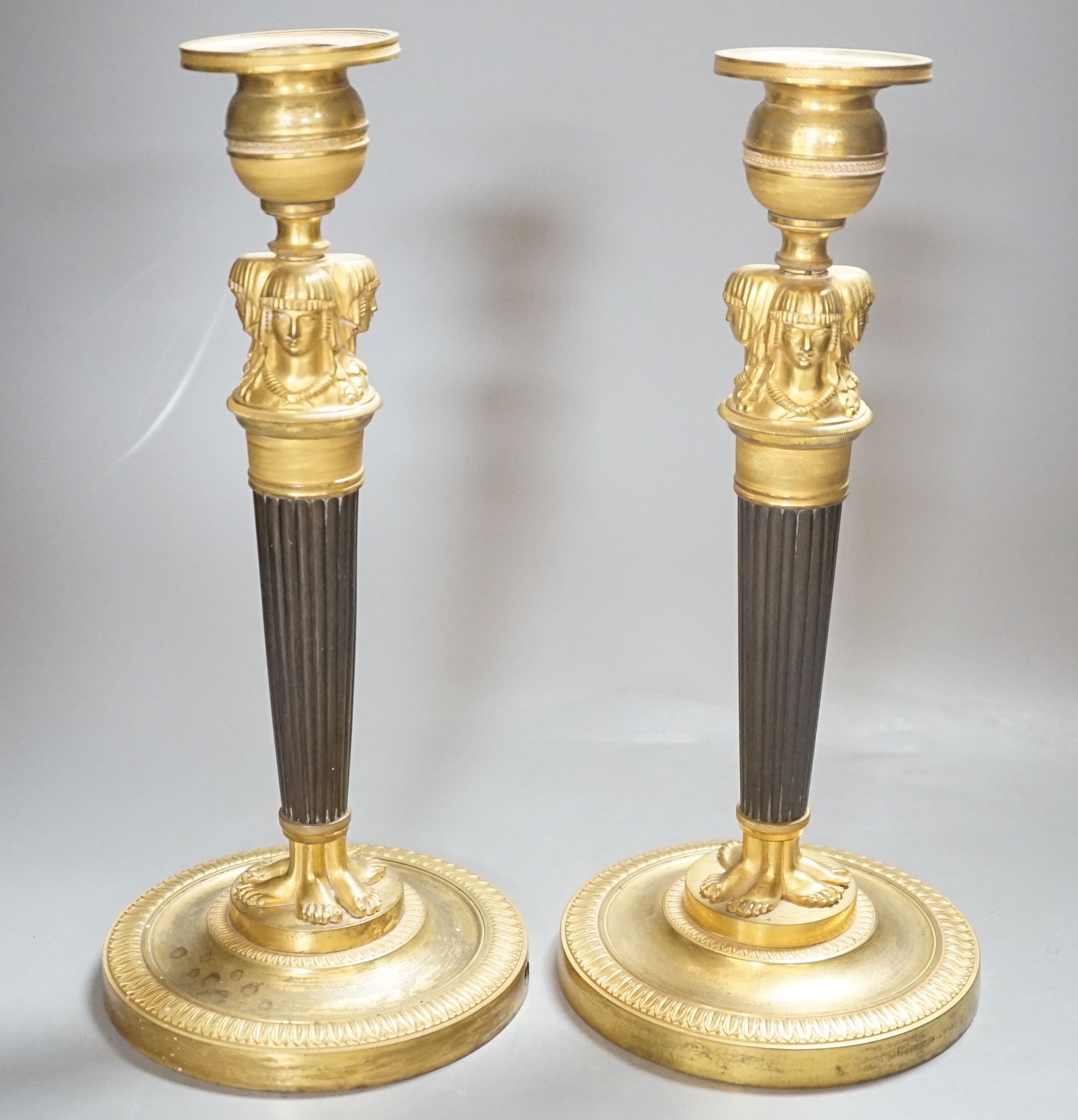 A pair of Empire style bronze and ormolu candlesticks - 29.5cm tall