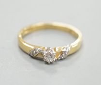 A modern 18ct gold and single stone diamond ring, with diamond chip set 'crossover' shoulders,