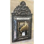 A Dutch brass framed cushion wall mirror, with ornate arched cresting, pierced and repousse with