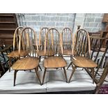 A set of six Ercol elm and beech comb back dining chairs