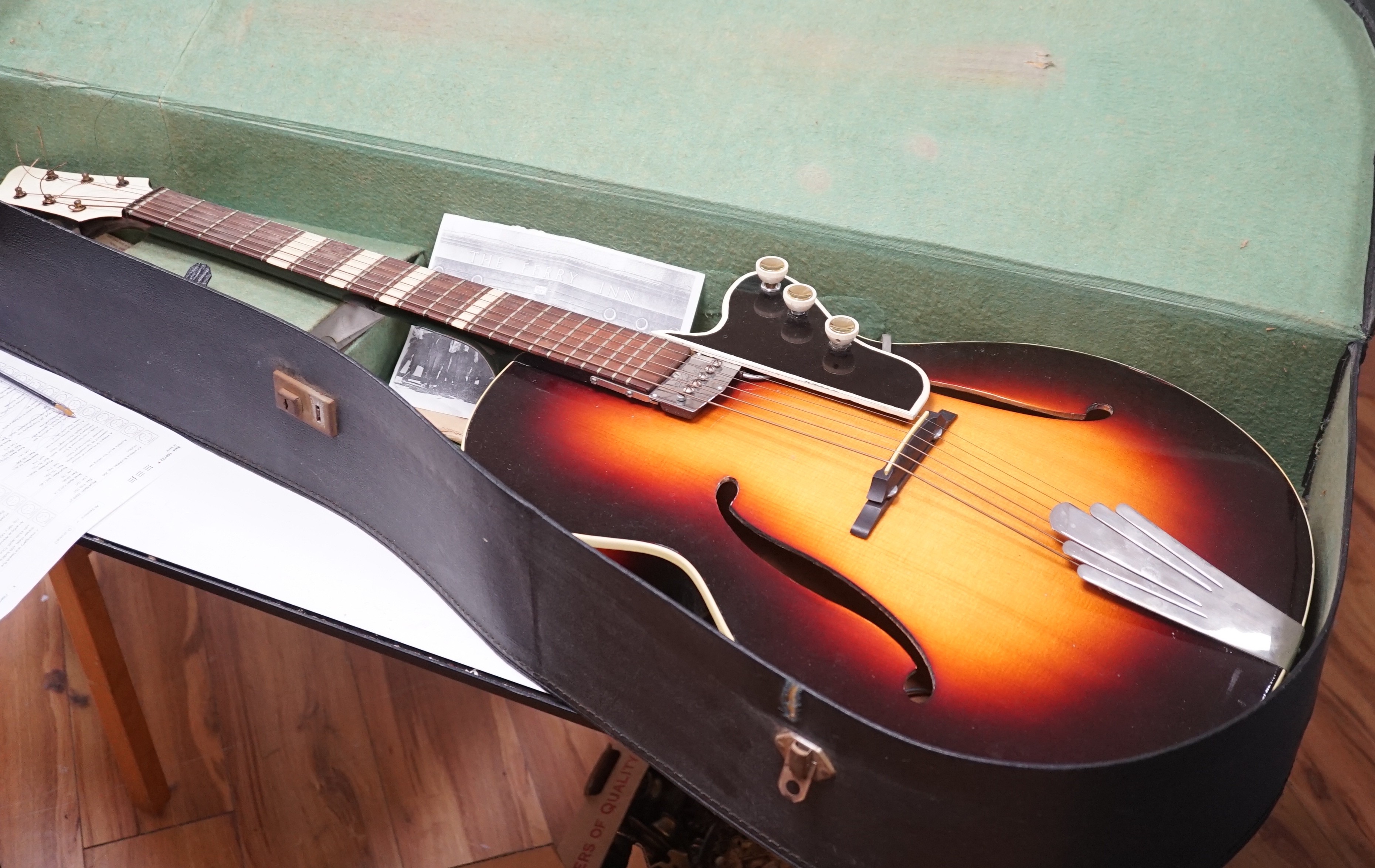 A 1950's Hofner style cut away sunburst guitar, with original case and sheet music