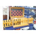 A 19th century mahogany games compendium with turned wood chess pieces and lead jockey and horse