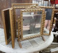 Two gilt framed triple dressing table mirrors together with a similar toilet mirror, largest
