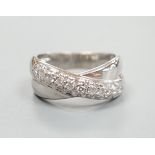 A modern 750 white metal and pave set set diamond crossover ring, size L/M, gross weight 5.9 grams.