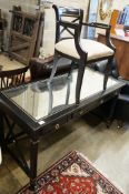 A painted mirrored three drawer ebonised writing table, length 140cm, depth 64cm, height 76cm
