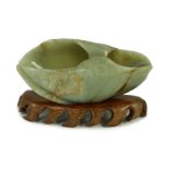A Chinese green and russet jade ‘lotus leaf’ brushwasher, 17th/18th century, carved as a curled