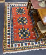 A Caucasian design red ground rug, 200 x 129cm