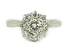 A modern 18ct white gold and nine stone diamond set flower head cluster ring, the central stone