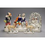 A pair of Victorian Staffordshire greyhounds and three Staffordshire pottery figures or groups -