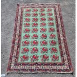 A Kirman Shah rug woven with floral bunches on a green ground within a conforming multi border 184cm