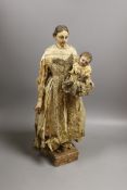 An 18th century Neopolitan painted wood Virgin and child group, 44cms high including stand.