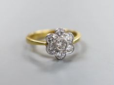 A modern 18ct gold and seven stone collet set diamond flower head cluster ring, size O, gross weight