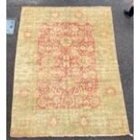 An Indian Agra carpet, with central field of stylised floral motifs on a red ground within a