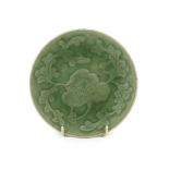 A Chinese celadon glazed small peony dish, Qing dynasty, moulded in relief with a peony flower and