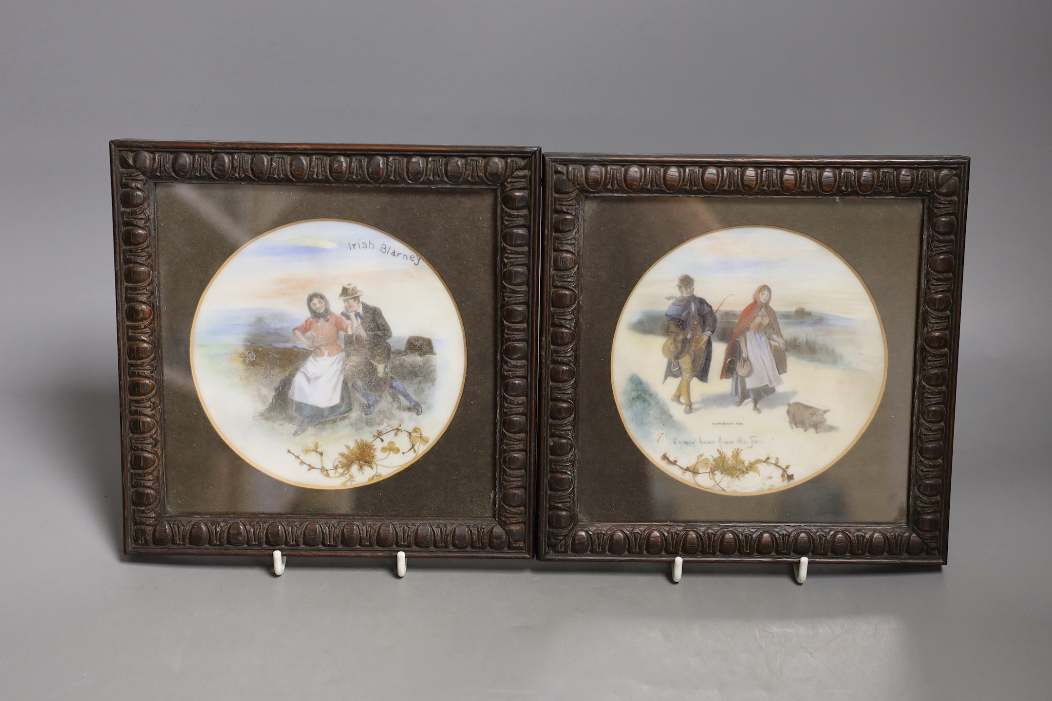 A pair of framed overpainted prints on glass, 13 cms diameter.