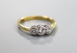 A modern 18ct gold and collet set three stone diamond set ring, size O, gross 3.8 grams, total