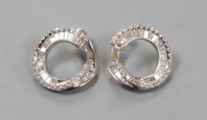 A modern pair of 750 white metal, round brilliant and graduated baguette cut diamond set open work