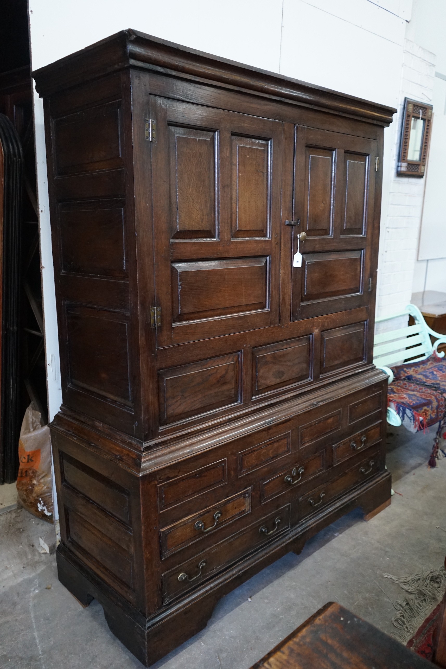 An 18th century panelled oak press cupboard, width 140cm, depth 56cm, height 185cm**CONDITION