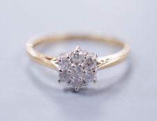 A modern 18ct gold and seven stone diamond set flower head cluster ring, size P, gross weight 2.4