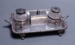 A late Victorian silver inkstand, with two mounted glass wells and central lidded compartment,