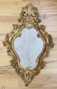 A reproduction gilt framed wall mirror, in the Rococo style, 73cm tall**CONDITION REPORT**PLEASE