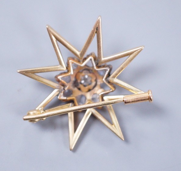 A yellow metal and diamond cluster set star brooch, 30mm, gross weight 6.6 grams.**CONDITION - Image 2 of 2