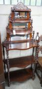 A late Victorian rosewood serpentine front six tier whatnot with mirror and barley twist support