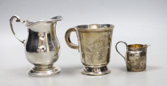 A 1960's silver cream jug, a small cream jug and a George V silver christening mug, 9.5 oz.**
