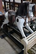 An early 20th century carved wood rocking horse on safety frame (re-painted), height 126cm**