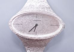 A lady's 1970's silver Longines manual wind wrist watch, with oval dial, on a textured silver