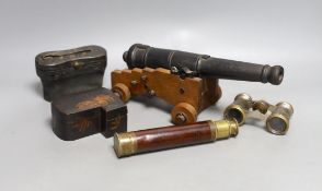 A model cast iron cannon on oak carriage, 26 cm long, two pairs of opera glasses, a telescope and