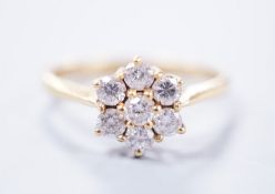 A modern 18ct gold and seven stone diamond set flower head cluster ring, size N/O, gross weight 2.