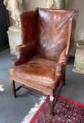 A George III style mahogany brown leather upholstered wing armchair, width 64cm, depth 60cm