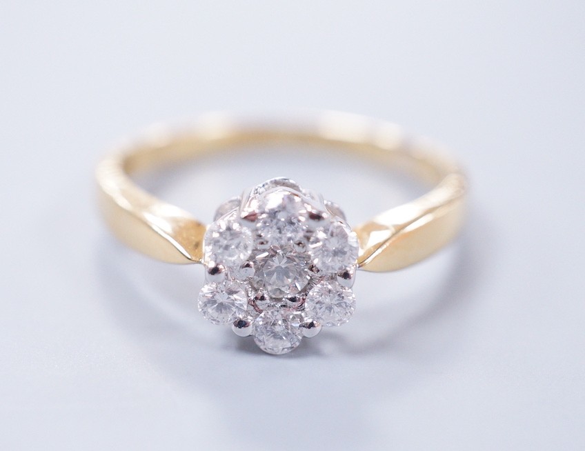 A modern 18ct gold and seven stone diamond set flower head cluster ring, size L, gross weight 2.9
