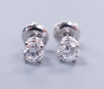 A pair of 18k white metal and solitaire diamond set ear studs, gross weight 0.9 grams, the toatal